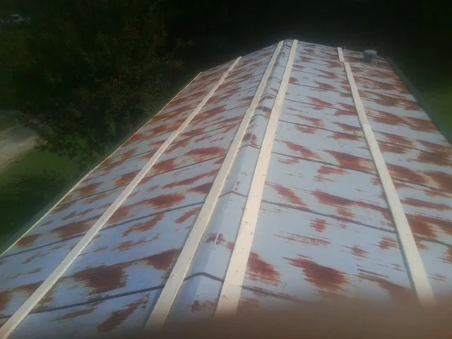 Rusted metal roof panels with new wood purlins before replacement — Storm Damage Roof Repair in Oak Ridge by Roofing Brothers