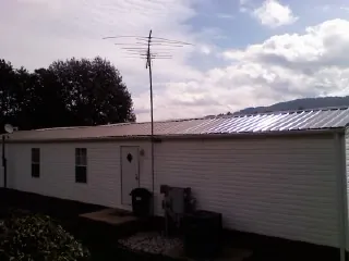 New metal roof on a single wide mobile home with a TV antenna in Oak Ridge