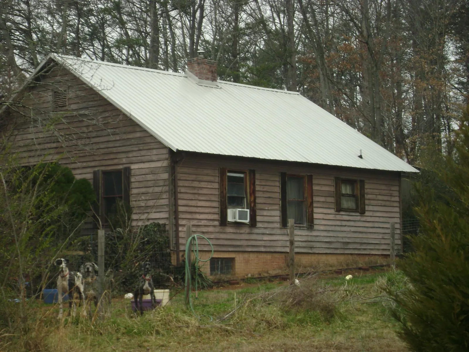 White metal roof on an old wood sided farmhouse, from a Metal Roof Installation job in Oak Ridge